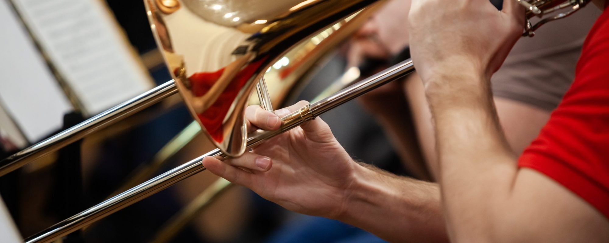 Hands of a musician playing a trombone A close-up of a fragment of a trombone in the hands of a musician